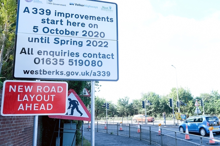 A photograph of a road sign beside a junction, notifying road users of highway development